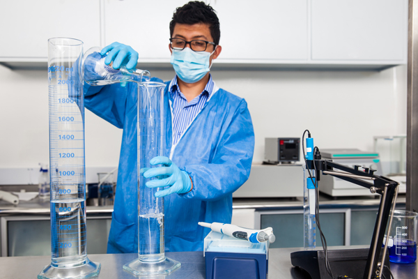 Scientist mixing solvents for preparation of buffer solution